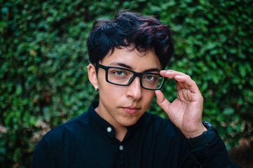 Close-up view of a transgender person posing on natural background.