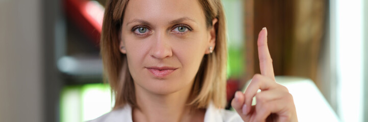 Female doctor pointing her finger up in medical office.