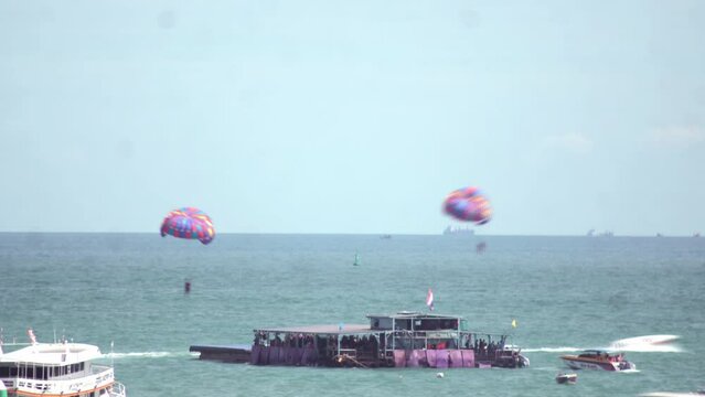 Time-lapse footage of people parasailing above the sea.