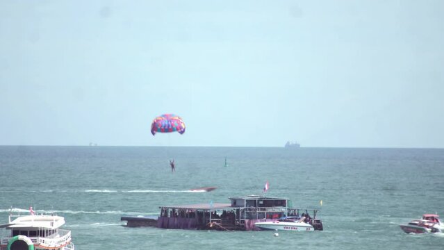 Time-lapse footage of people parasailing above the sea.
