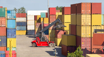The red stacker stacks shipping containers at the port warehouse terminal
