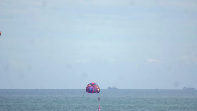 Time-lapse footage of people parasailing above the sea.