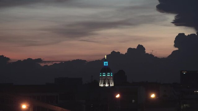 Rain clouds are forming above the city of Bangkok, Thailand during sunset.