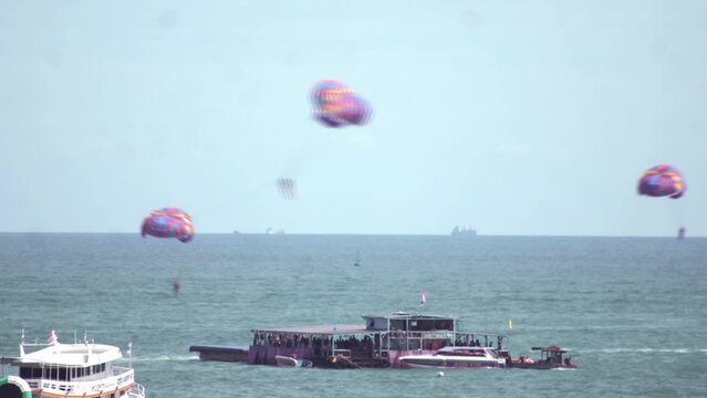 Time-lapse footage of people parasailing above the sea.