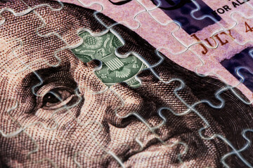 A fragment of a 100 US dollar bill assembled from puzzles and a fragment of a 1 dollar bill with a...