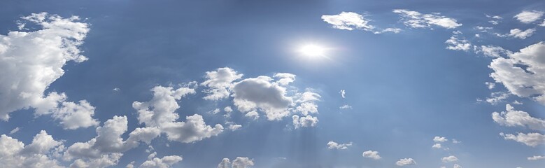 blue sky with fluffy white clouds and sun. panoramic sunny background.