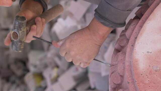 man with his hammer and chisel shaping a table, handwork, sculpture, latino old man, artisan working the pink quarry stone