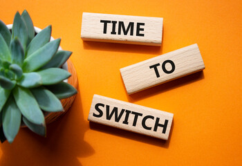 Time to Switch symbol. Concept word Time to Switch on wooden blocks. Beautiful orange background....