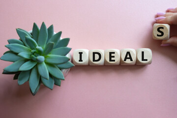 Ideals symbol. Wooden blocks with word Ideals. Businessman hand. Beautiful pink background with...