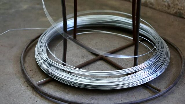Steel reinforcement coils are wrapped using a special machine. Metal base