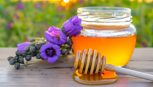 Sweet honeycomb and closed jar and stick with black cumin flowers on wooden table