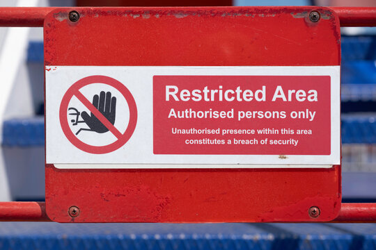Warning Sign on a gate. Red and white restricted area sign, authorized persons only, with hand icon, on the deck of a ferry