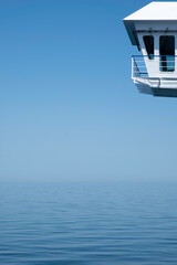 Wheelhouse or Bridge of a ship, viewed from the side. Quiet calm blue sea surface. Port (left side) © Henk Vrieselaar