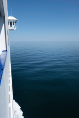 Wheelhouse or Bridge of a ship, viewed from the side. Quiet calm blue sea surface with bow wave. Starboard (right side) © Henk Vrieselaar