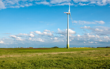 Wind turbine on grassy field - 624617840