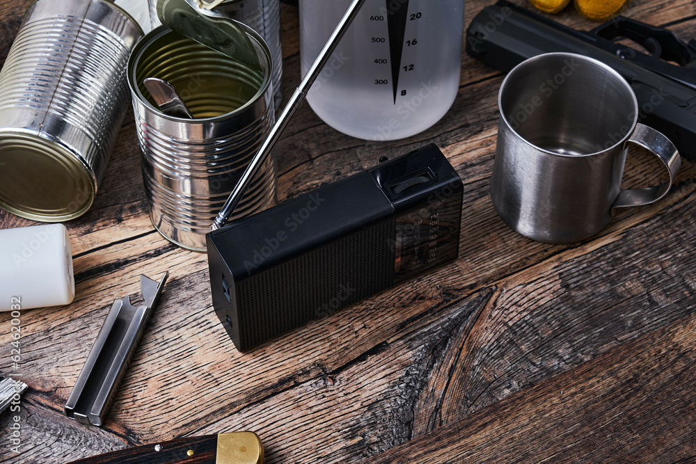 Wall mural Radio receiver and disaster preparedness kit on wooden table.