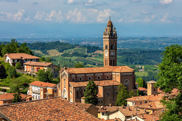 Catholic church among houses with red roofs in small italian town.