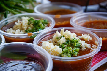 The sauce is placed in a plastic cup.