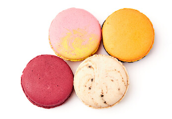 Top view of 4 colorful macarons (pink, red, orange and cream-brown) isolated on white background.