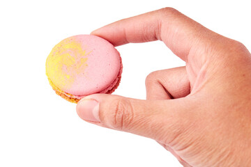 Hand holding pink macaron isolated on white background. Front side of macaron.