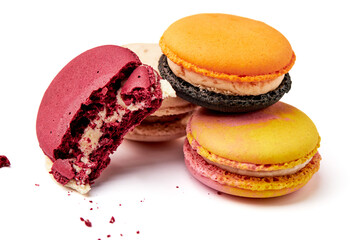 Close up of 4 colorful macarons. (pink, red, orange and cream-brown) Half-bitten red macaron isolated on white background.