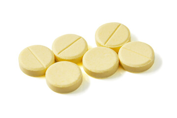 Many Circle-shaped yellow pills isolated on a white background.