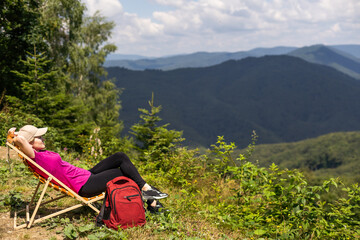 a woman rests after a hike in the mountains