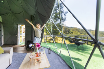 woman inside a geodesic glamping tent