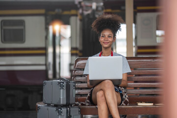 Young woman girl female sitting use computer laptop and travel bag suit case on the floor at station