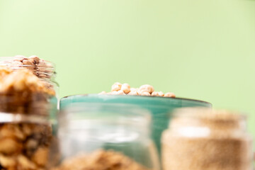 bowl full of chickpeas on wooden table with green background. Top view.
