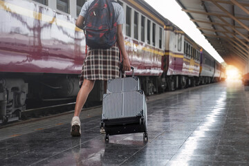 Young female traveler walking standing with a suitcase at train station. woman traveler tourist walking standing smiling with luggage at train station