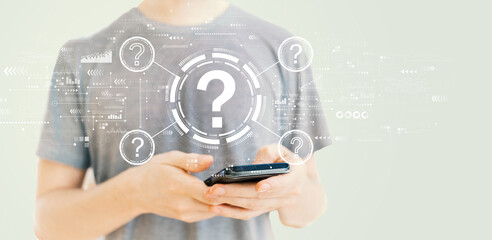 Question marks with young man using a smartphone