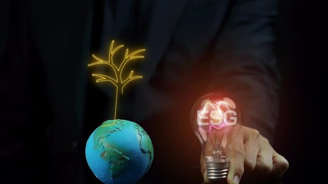 Businessman showing light bulb with ESG icons and virtual tree. Net zero greenhouse gas emissions target. Climate neutral long term strategy. Ecological, renewable energy and save environment concept.