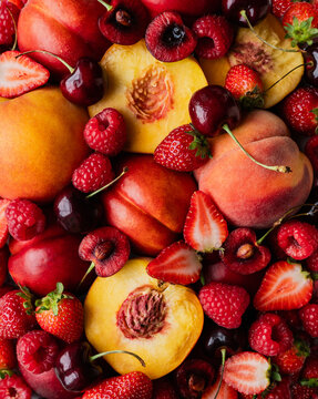 Close up of mixed summer fruit: berries, peaches, cherries.