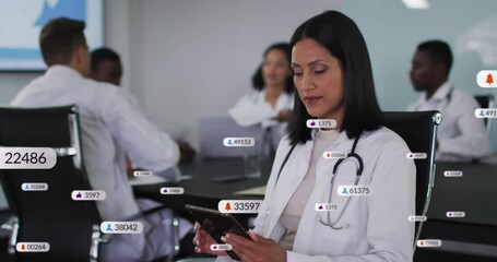 Animation of social media data processing over biracial female doctor using tablet - Powered by Adobe