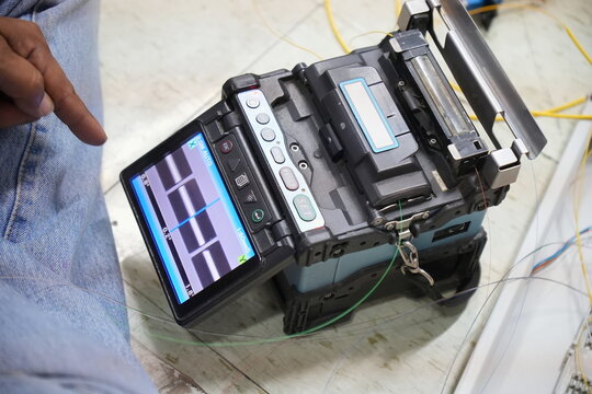 Technician working, fiber optic cable splicing and testing cables with optical power meter 