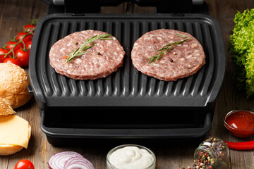 Burger cutlets are fried on a smart electric grill, homemade burgers.