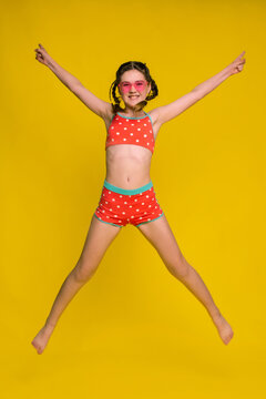 tweens happy girl in swimsuit jumping on yellow background. love summertime content