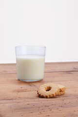 glass cup with milk and cookies on wooden rustic table