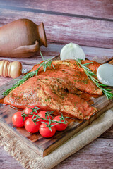 fresh iberian pork secret marinated with tomato, onion and rosemary, on a wooden board.