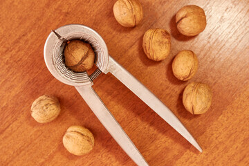 Walnuts are crushed with a nutcracker. Kitchen appliances for work in the kitchen.
