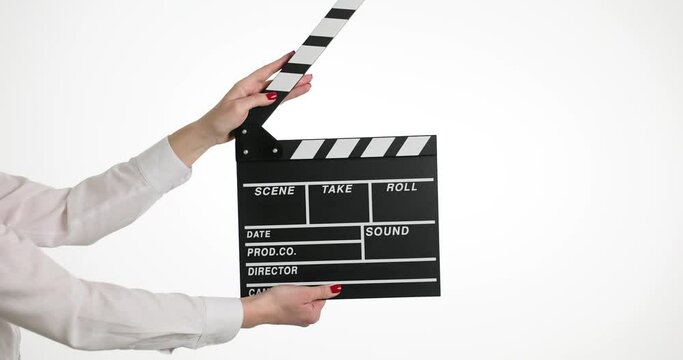 Female hands clip using black clapboard to give signal to start shooting film. Woman assistant against isolated white background during set