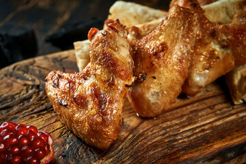 Chicken wings grilled on a charcoal grill on a board. A classic barbecue