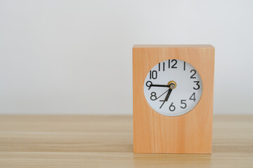 Wooden clock isolated on the table and white background. Copy space