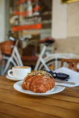 Morning coffee and croissant with reading material