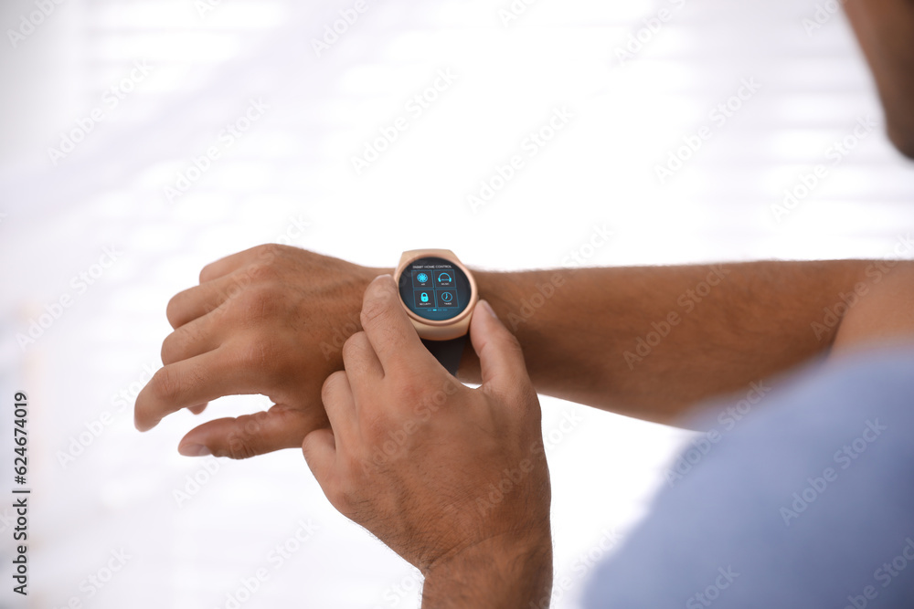 Poster man setting smart home control system via smartwatch against light background, closeup. app interfac