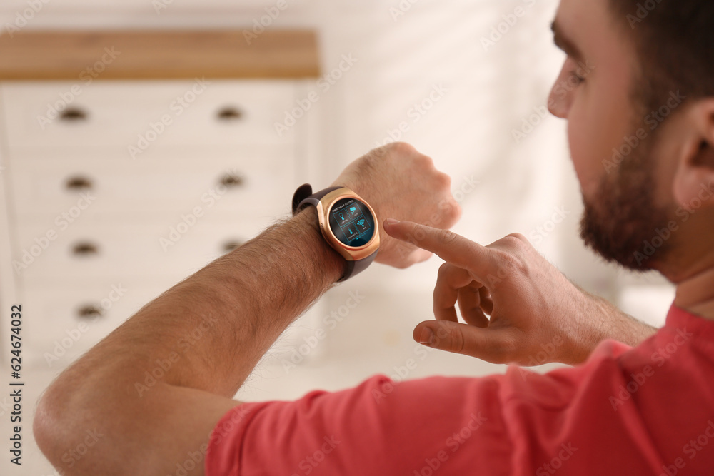 Poster man setting smart home control system via smartwatch indoors. app interface with icons on display