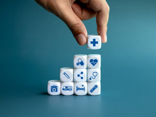 Healthcare medical, wellness plan and insurance concept. Health, care and medical element icon symbols on clean white blocks stacking as a graph arranged by doctor's hand on blue background. - obrazy, fototapety, plakaty