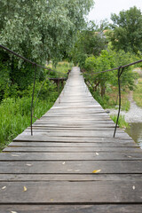 Obraz premium Suspension wooden bridge over the river