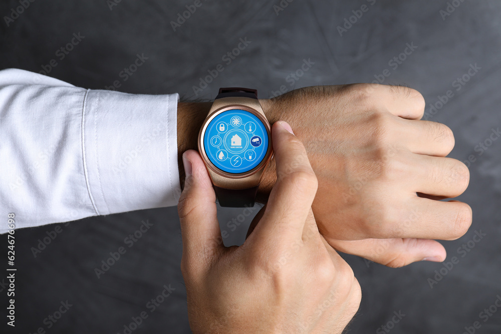 Poster man setting smart home control system via smartwatch against dark grey background, closeup. app inte